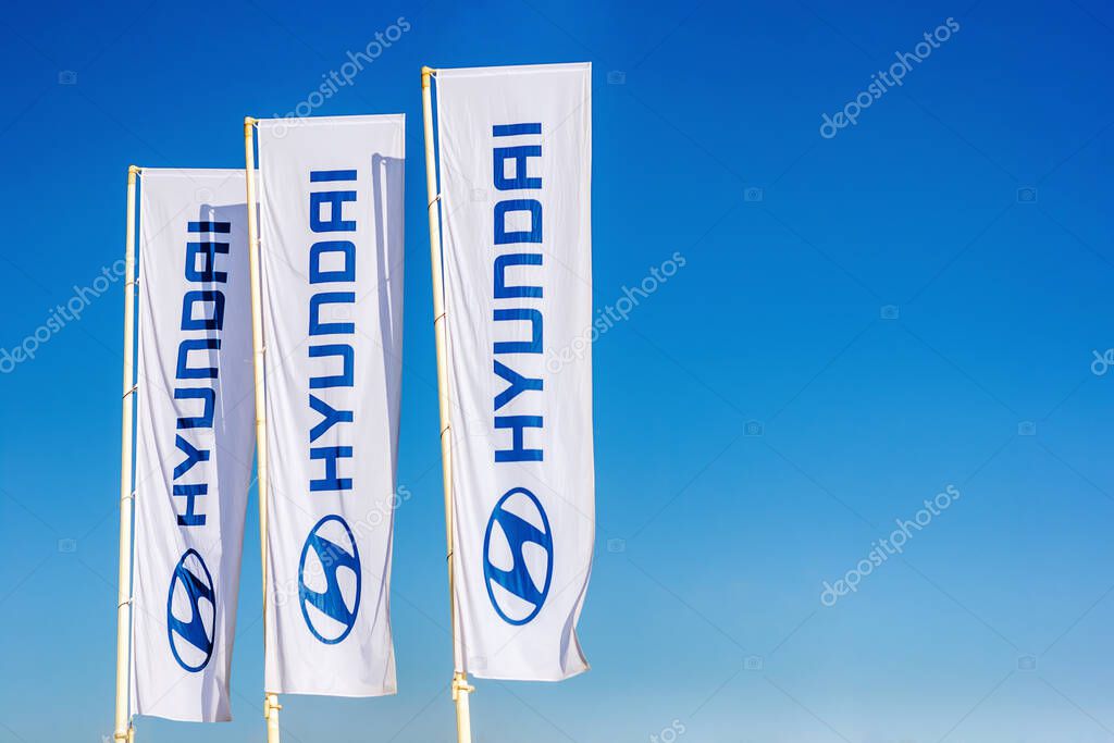 Hyundai car dealer emblem and logo on flags in blue sky, Moscow, 18 Feb 2021