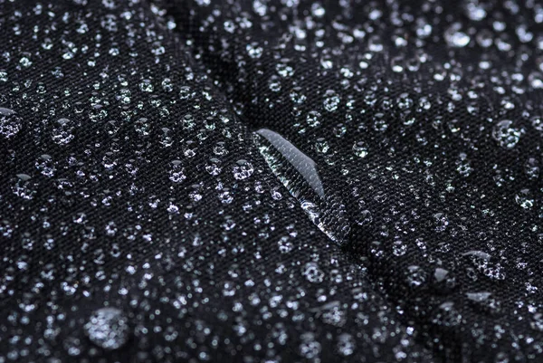 Water drop on black fabric, waterproof test of laptop bag