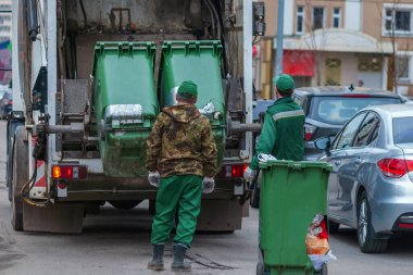 Çöp kamyonu ve işçiler Moskova 'daki yerleşim bölgesinde 2021 Nisan' ında katı atık topluyorlar.
