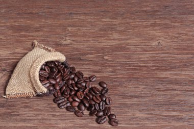 Kahve çekirdekleri tahta zeminde ayrı torbalarda.