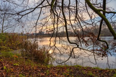 Küçük bir gölün üzerinde güzel bir günbatımı resmi. Fotoğraf: Lomma Beach, Scania, İsveç