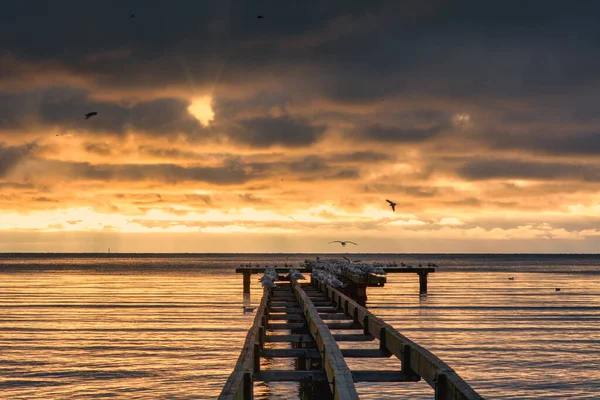 Um lindo pôr-do-sol dourado sobre um velho calçadão. Foto de Hallevik, Blekinge, Suécia — Fotografia de Stock