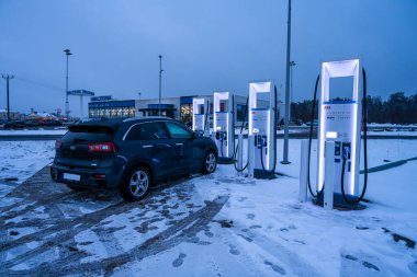 Bir elektrikli araç, EV şarj istasyonu 175 kW ultra hızlı şarjlı. Fotoğraf çekildi. Alacakaranlık.
