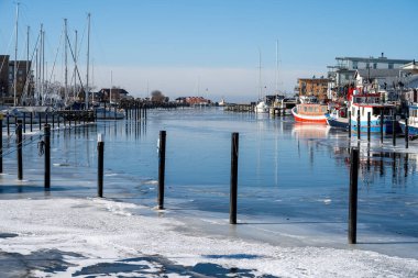 Soğuk bir kış günü yat limanında buz. Mavi gökyüzü arka planı. Fotoğraf: Lomma, İsveç