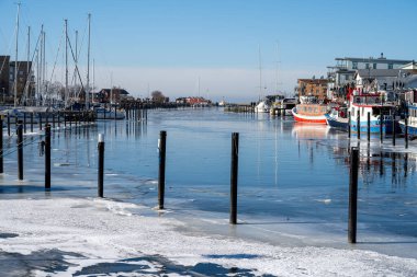 Soğuk bir kış günü yat limanında buz. Mavi gökyüzü arka planı. Fotoğraf: Lomma, İsveç