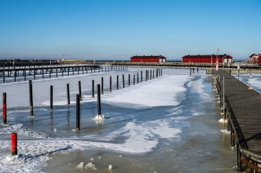 Yat limanını kaplayan buz. Mavi gökyüzü arka planı. Fotoğraf: Lomma, İsveç