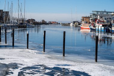 Soğuk bir kış günü yat limanında buz. Mavi gökyüzü arka planı. Fotoğraf: Lomma, İsveç