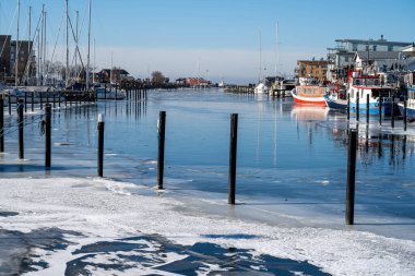 Soğuk bir kış günü yat limanında buz. Mavi gökyüzü arka planı. Fotoğraf: Lomma, İsveç