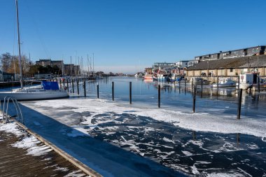 Soğuk bir kış günü yat limanında buz. Mavi gökyüzü arka planı. Fotoğraf: Lomma, İsveç