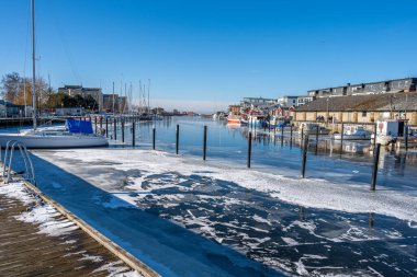 Soğuk bir kış günü yat limanında buz. Mavi gökyüzü arka planı. Fotoğraf: Lomma, İsveç