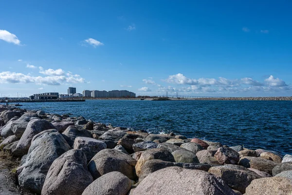 Ön planda dalga kırıcı olarak büyük kayaları olan bir okyanus körfezi. Fotoğraf: Malmö, İsveç