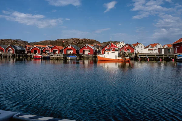 Un pintoresco pueblo de pescadores en la costa oeste sueca. Cabañas tradicionales de mar rojo y un cielo azul en el fondo —  Fotos de Stock