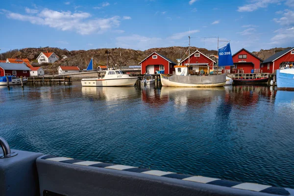 Un pintoresco pueblo de pescadores en la costa oeste sueca. Cabañas tradicionales de mar rojo y un cielo azul en el fondo —  Fotos de Stock