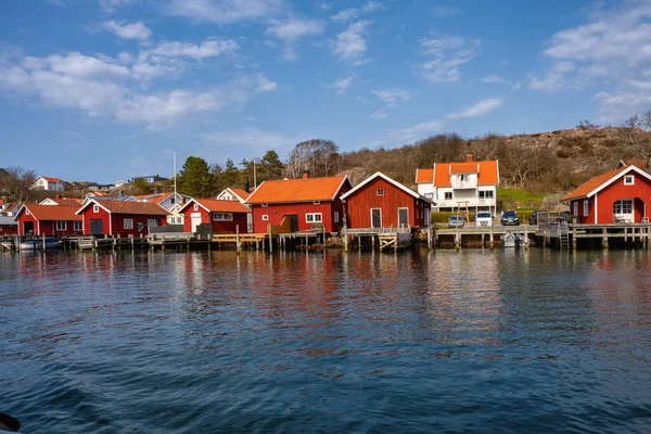 A picturesque fishing village on the Swedish West coast. Traditional red sea huts and a blue sky in the background — Stock Photo, Image