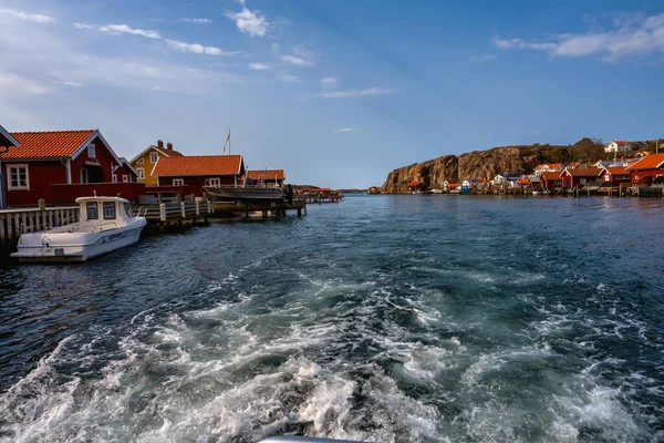 Egy festői halászfalu a svéd nyugati parton. Hagyományos vörös tengeri kunyhók és kék ég a háttérben — Stock Fotó