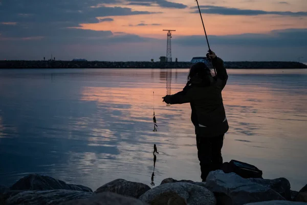 A woman fishing in a beautiful sunset. Picture from Malmo, Sweden — Stock Photo, Image