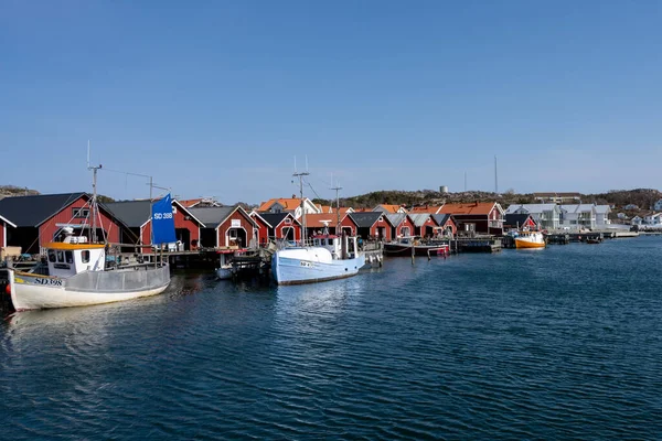 Un pintoresco pueblo de pescadores en la costa oeste sueca. Cabañas tradicionales de mar rojo y un cielo azul en el fondo — Foto de Stock