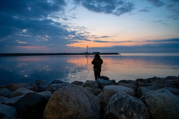 A woman fishing in a beautiful sunset. Picture from Malmo, Sweden — Stock Photo, Image