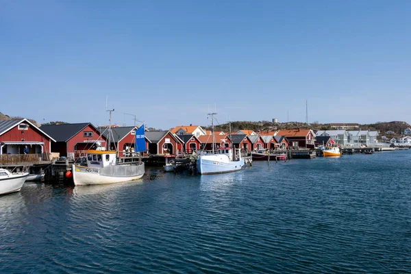 Un pittoresco villaggio di pescatori sulla costa occidentale svedese. Tradizionali capanne rosse e un cielo blu sullo sfondo — Foto Stock