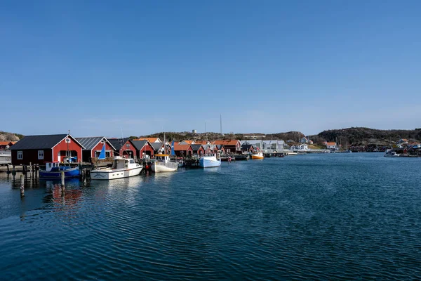 Un pittoresco villaggio di pescatori sulla costa occidentale svedese. Tradizionali capanne rosse e un cielo blu sullo sfondo — Foto Stock