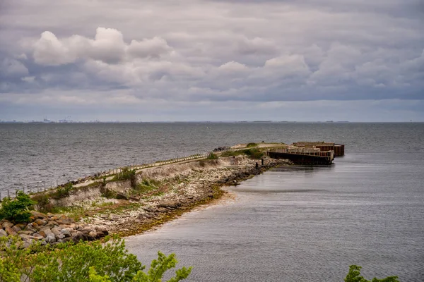 A beautiful, dramatic sky over the ocean. An old pier in the foreground — Stock fotografie