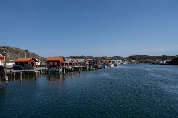 Un village de pêcheurs pittoresque sur la côte ouest suédoise. Cabanes traditionnelles de la mer rouge et un ciel bleu en arrière-plan — Photo