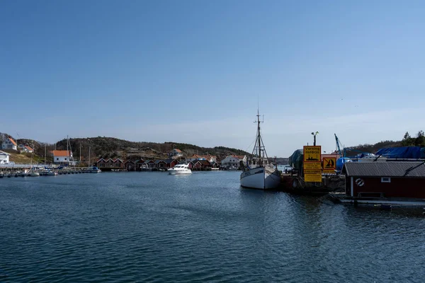 Un pittoresco villaggio di pescatori sulla costa occidentale svedese. Tradizionali capanne rosse e un cielo blu sullo sfondo — Foto Stock