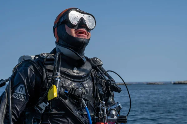 A closeup picture of a scuba diver waiting for the dive boat to get into position so he can enter the water. Ocean and blue sky in the background — Stock Photo, Image