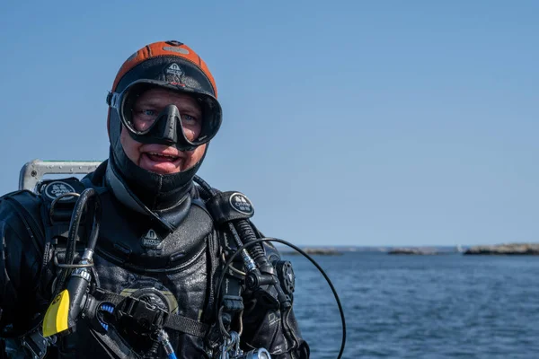 Une photo rapprochée d'un plongeur attendant que le bateau de plongée se mette en position pour qu'il puisse entrer dans l'eau. Océan et ciel bleu en arrière-plan — Photo