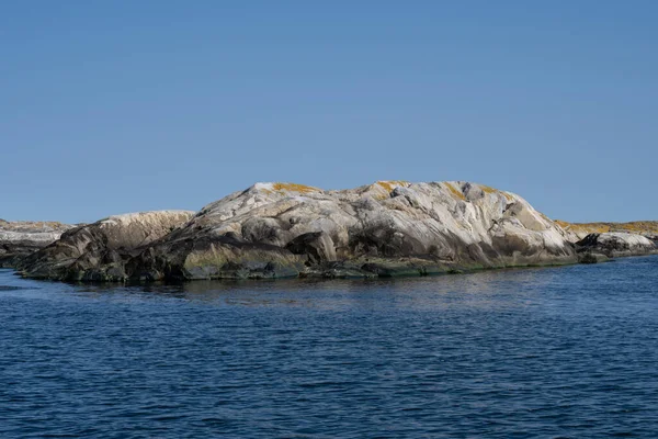Uma foto de uma bela ilha rochosa. Oceano e céu azul no fundo — Fotografia de Stock