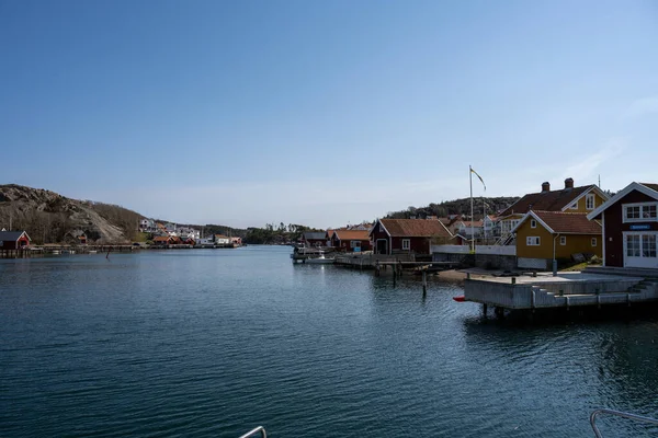 Un pittoresco villaggio di pescatori sulla costa occidentale svedese. Tradizionali capanne rosse e un cielo blu sullo sfondo — Foto Stock