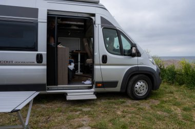 Okyanusun kenarında park etmiş bir karavan.
