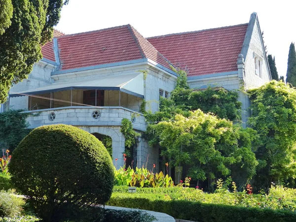 Evin ön tarafı palmiye ağaçları ve lianalar yüzünden zar zor görülebiliyor. Kadife mevsimi. Gaspra köyünün alanı (Yalta 'nın bir kısmı, 70 kilometreden fazla bir alan)).