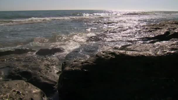 Fale morza uderzyły w kamienny brzeg. Siła fal wyostrza kamień dzień po dniu. Przylądek morski. — Wideo stockowe