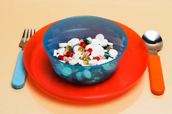 Different particolored pills on a plate — Stock Photo, Image