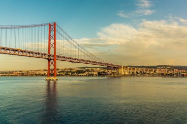 Portekiz, Lizbon 'daki 25 Nisan köprüsüne baktığımızda sabahın erken saatlerinde sonbaharda gün doğumunda Tagus nehrinden