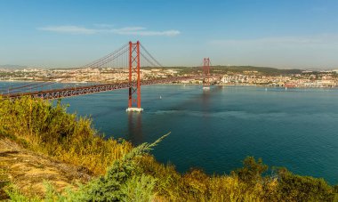 Tagus nehri boyunca 25 Nisan devriminden sonra adlandırılan köprüyü ve Portekiz 'in Belem ilçesini gösteren bir manzara