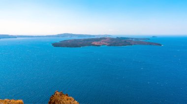 Skaros Kayası, Santorini 'den yazın Nea Kameni volkanik adasına doğru bir manzara