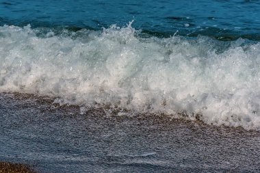 Yazın Perissa, Santorini sahilinde dalgalar kopuyor.