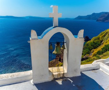 Yazın Santorini, Oia köyünde, kalderanın kenarında ıssız bir çan kulesi.