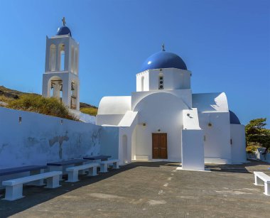 Yazın Oia, Santorini köyünün dışında mavi kubbeli küçük yerel bir kilise manzarası.