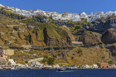 Fira 'ya giden bir tekneden, Santorini' nin yazları şehri ve eski limanı gezdirdiği bir manzara.