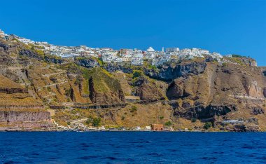 Fira 'ya giden bir tekneden manzara, Santorini yazları kenti ve eski limanı gösteriyor.