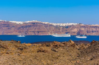 Volkanik ada Nea Kameni, Santorini boyunca Thira ve Caldera 'nın arka planında yaz mevsiminde bir manzara.