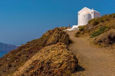 Yazın Santorini 'de küçük bir kiliseye giden Caldera yolu boyunca bir manzara.