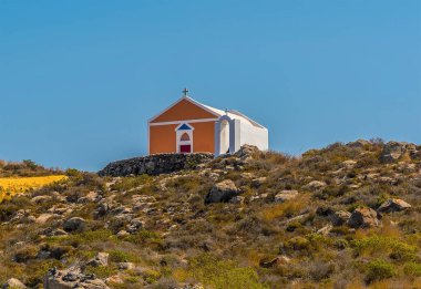 Yazın Oia kasabası yakınlarındaki Caldera kavşağından Santorini 'de küçük bir kiliseye doğru bir manzara.