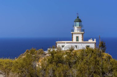 Santorini, Akortiri 'deki deniz fenerine giden ağaçların arasından bir manzara.