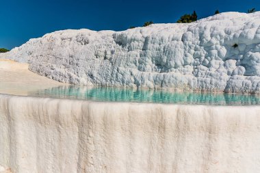 Türkiye 'nin Pamukkale kentinde masmavi suyla dolu sığ kireçtaşı havuzlarından oluşan ışıl ışıl beyaz teraslar