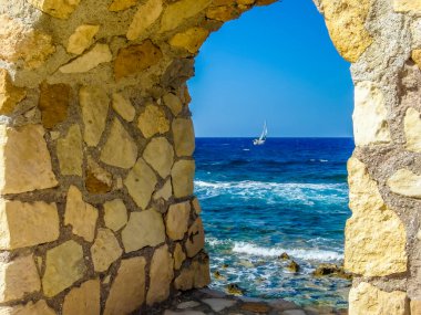 Girit 'in başkenti Chania Limanı' nın deniz duvarındaki bir kemer tarafından çerçevelenmiş Akdeniz 'e bir bakış.
