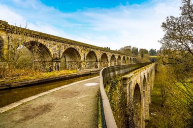 Chirk Aqueduct ve Wales 'deki demiryolu viyadük manzarası. Demiryolu viyadük su kemerinin üzerine inşa edilmiştir. Bu da demiryolu taşımacılığının kanal taşımacılığından daha üstün olduğunu sembolize eder.